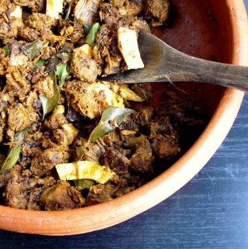 Indian style beef fry with coconut in terracotta bowl