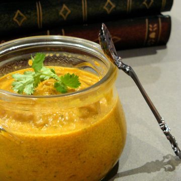 Tomato onion chutney in glass jar with a spoon on the side