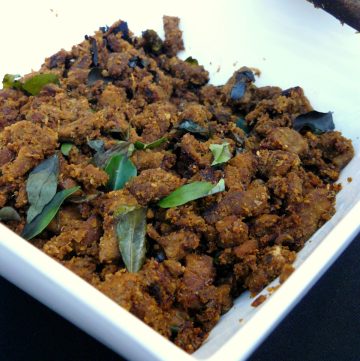 Indian style beef fry with spices and curry leaves in white bowl