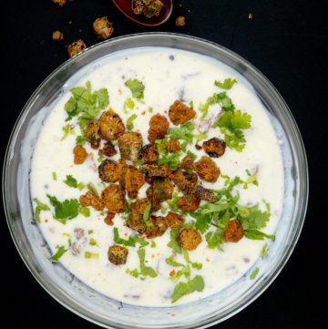 Yoghurt dip with fried okra served in glass bowl