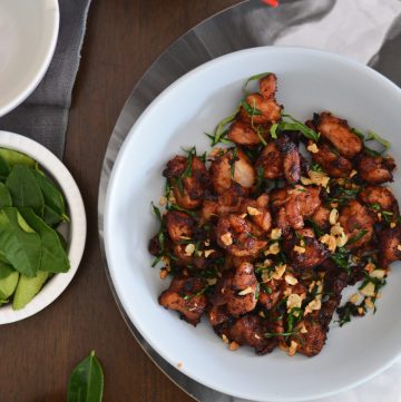 Stir fried chicken with lime leaves and garlic served in light blue bowl