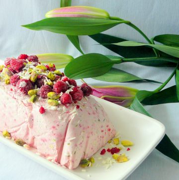 Ice Cream terrine with raspberries, white chocolate and pistachios served on white platter