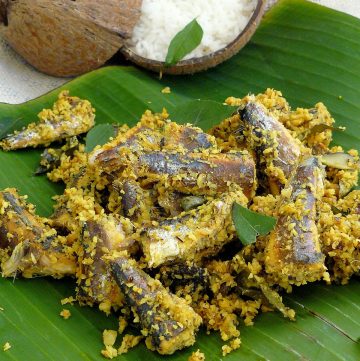 Indian style sardines with grated coconut served with rice on banana leaf
