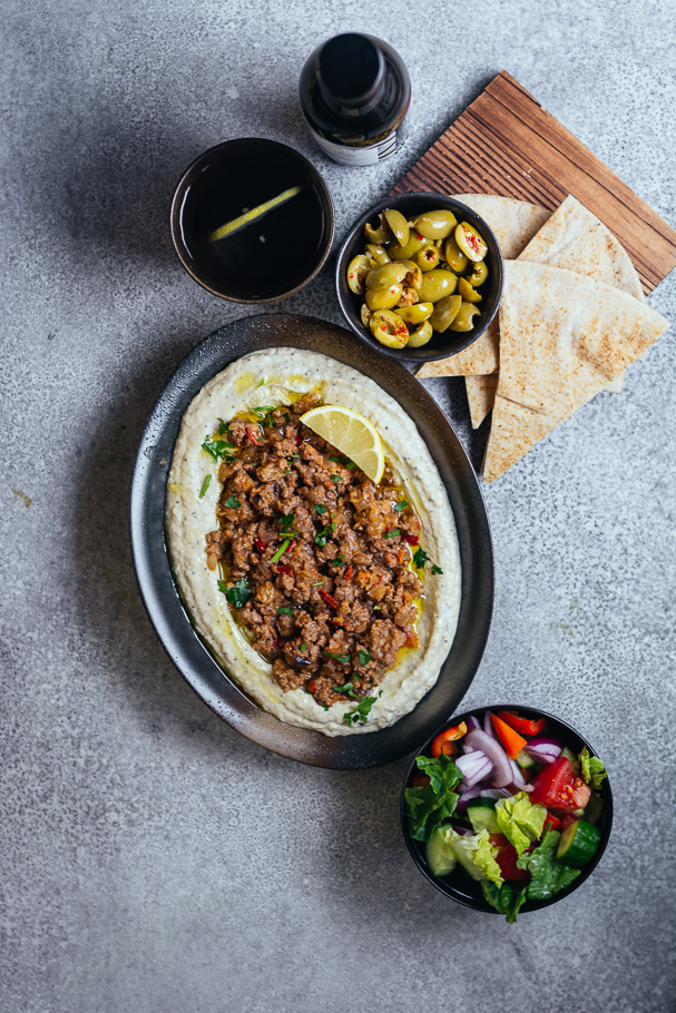 Brinjal dip topped with minced lamb served in oval black plate
