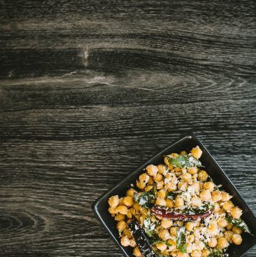 Chickpeas with spices and grated coconut in black bowl