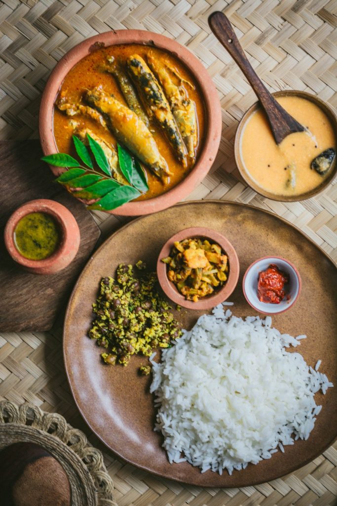 terracotta plate with rice, sardine curry and veggies