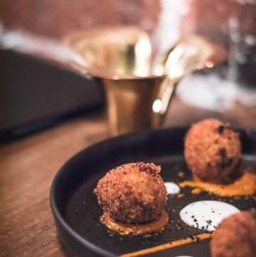 Indian inspired arancinis on black plate