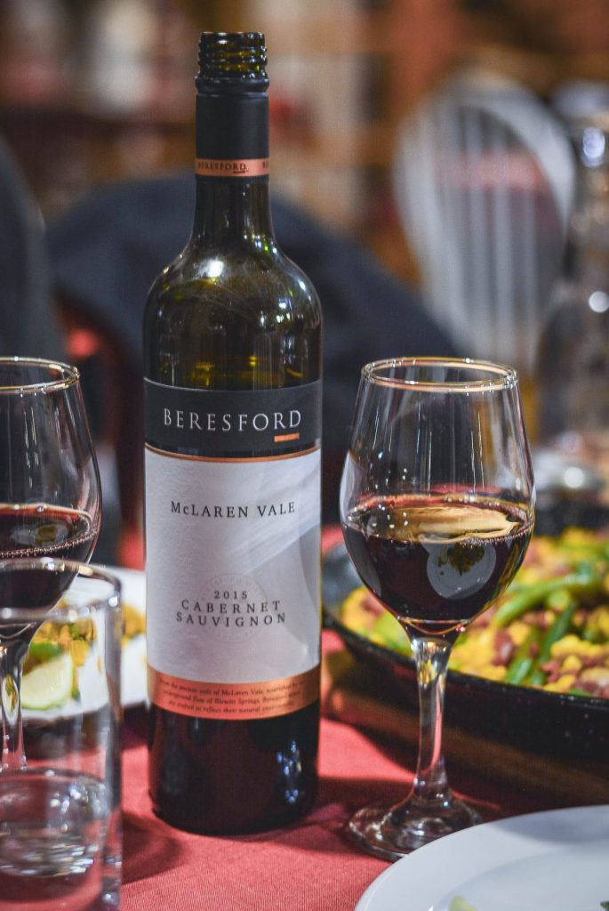 red wine in glass alongside bottle