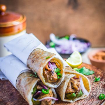 three Indian chicken flatbread rolls on brown surface